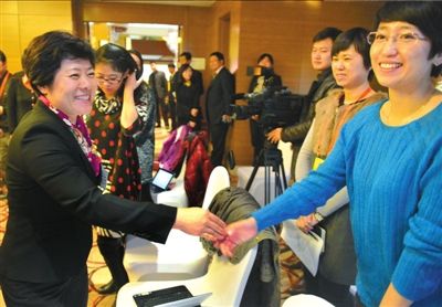 朝阳区区长吴桂英接受采访，与记者们握手。本报记者张斌摄