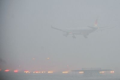 2月1日下午，一架客机降落在雾霾中的北京首都机场。（记者陶冉摄）