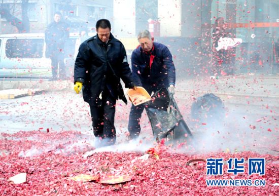 2月9日，大连两名工作人员在街头清理鞭炮碎片。新华社发(吕文正 摄)
