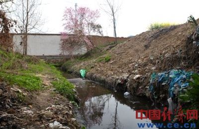 散发着刺鼻臭味的污水从白云纸业北侧围墙处流出。