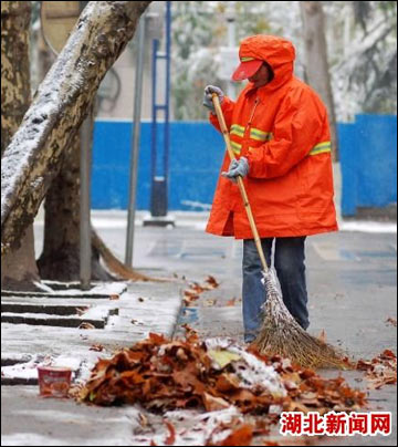 环卫工人清理路面积雪,落叶(记者:张芹摄)