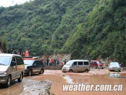 带着山泥的洪水淹没了公路,经过紧急抢修后恢复了通车。