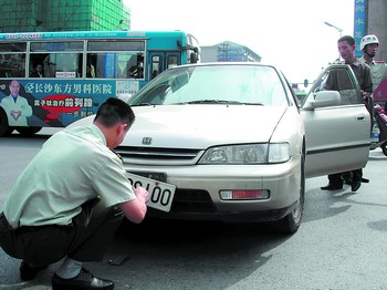 查违法 警备纠察人员查获一假军车,正将假军牌取下来. 陈安乐 摄