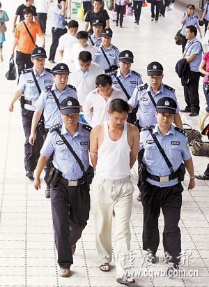 犯罪嫌疑人被民警押送出火车北站记者 吴子敬 摄