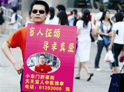 荆楚网消息(楚天金报 图为:熊胜明在中南路举牌征婚 记者饶纯武摄