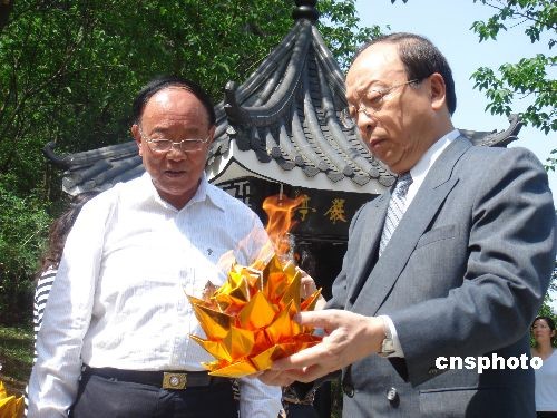 图为蒋孝严(右)按照中国传统家祭之礼举行祭拜仪式,为母亲献化冥币冥