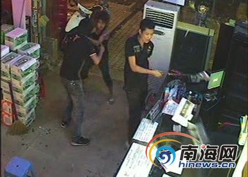 这伙人中一男子用砍刀将网吧前台的电脑显示器砸坏(翻拍监控录像)