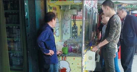 超市门口的抓烟机人气挺旺。 游乐场里经常能看到投币抓娃娃的娃娃机,但在另外一些地方,这些机器却变了味,里面的娃娃被香烟取代,抓到香烟还能折现。5月9日,市民王先生拨打新安晚报热线,反映淝河路张巷菜市场附近,有两家超市门口放有抓烟机,投币1元钱,有机会抓到价值数十元的香烟,吸引了不少年轻人。可以说是变相赌博,而且输多赢少,骗钱的。 记者探访:抓到香烟的是极少数 5月11日上午10点多,记者来到位于淝河路的张巷菜市场,找到了一家旺福超市门口摆放的两台柜式抓烟机,里头放了上百盒香烟,品类