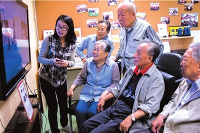 在社区养老院内,志愿者教老人们怎样视频聊天