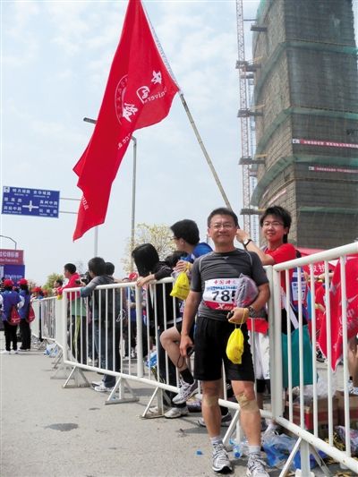 2011年扬州马拉松后,丁泽军在中国科大校旗前留影