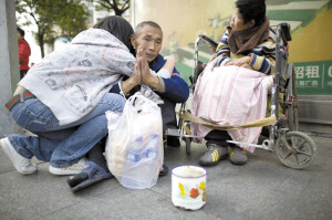 昨日，慧慧在东城东湖花园广场拥抱为女儿行乞的任老伯，并为他买来食品。 本版图片除署名外均由记者 马闪山 摄