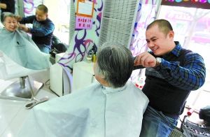 在阿兵美发厅，阿兵正在为78岁的王大妈修剪头发。本报记者 方非摄