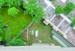 　　弹子石国际社区一楼业主把阳台外的一片绿化地圈了起来，作为自家私用。 重庆晨报记者 王海 摄 
