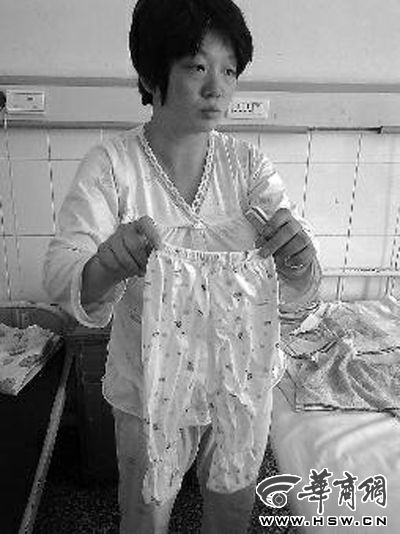 24日下午，失去孩子的董女士从病房柜子里拿出为儿子准备的一条裤子 本报记者 贾凡 摄