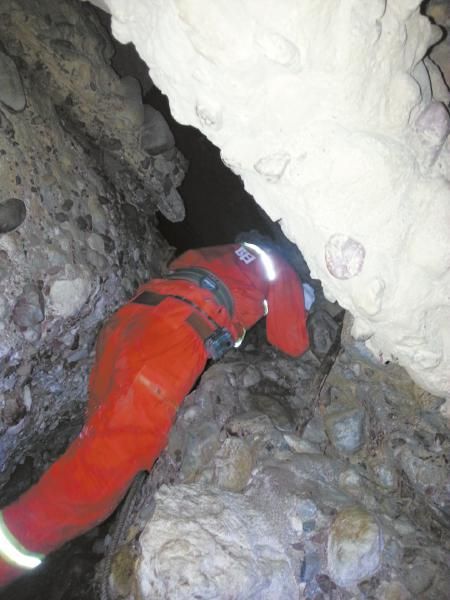 消防官兵在狭窄的溶洞实施救援。