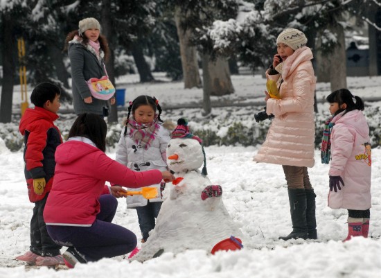图文:孩子们在家长带领下到公园堆雪人