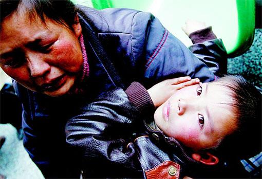 7岁儿子身患肾积水，45岁的丈夫刘福成狠心离去，33岁的汉中市镇巴县刘家沟农民冯修香抱着儿子伤心欲绝。 本报记者 吴暗彪摄