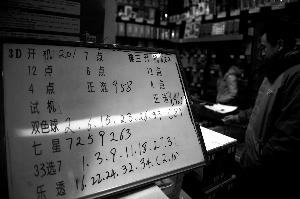 昨日，朝内北小街一家投注站，白板上标注了刚刚获得千万奖金的双色球号码。本报记者 杨杰 摄