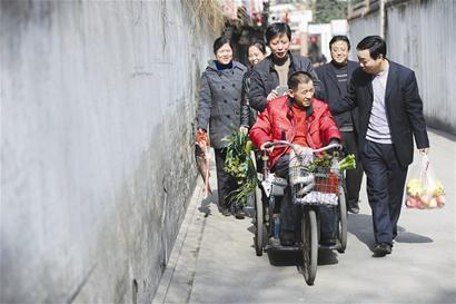 輪椅邊圍滿了人，大家有說有笑，場面十分溫馨