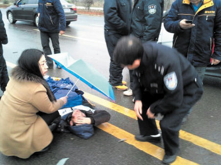过路女子为车祸重伤者撑伞遮雨半小时的感人一幕被其他路人看到后拍了下来。网友供图