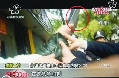 4月1日小摊主举刀要砍城管。视频截图 4月1日小摊主举刀要砍城管。视频截图