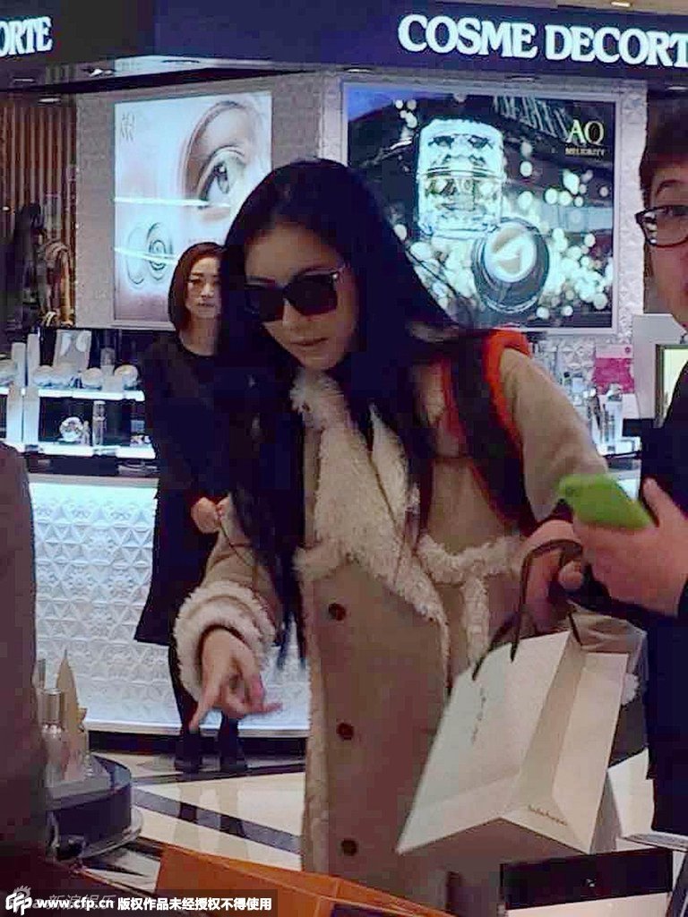 组图：张柏芝购物好心情 背双肩包扫货挑化妆品