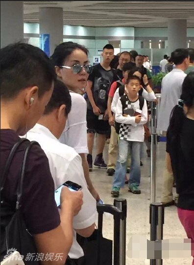 组图:王菲疑带李嫣现身机场 身材纤瘦穿着时髦