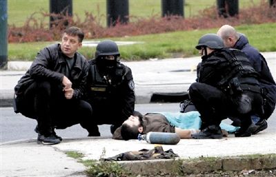 10月28日，在位于萨拉热窝的美国驻波黑使馆前，一名枪手(中)被警方制服。新华社发
