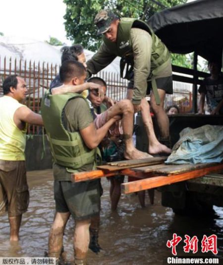 菲律宾南部连日来遭到热带风暴“天鹰”引发的大雨和洪水重创，受灾人口超过10万人。菲律宾红十字会18日上午透露，死亡人数已经升至447人。灾情最惨烈的卡加延德奥罗市和伊利甘市17日相继宣布进入“灾难状态”。图为士兵帮助一名伤者登上卡车。