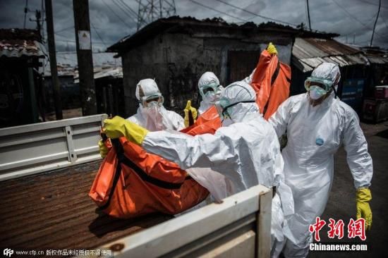 当地时间2014年10月15日，利比里亚首都蒙罗维亚，一支利比里亚红十字会殡仪小组的成员移走了埃博拉疑似患者Mambodou Aliyu的遗体，Mambodou今年仅有35岁。图片来源：CFP视觉中国