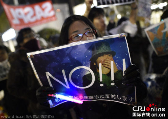 当地时间2014年12月9日，在日本东京，有示威者手持标牌抗议将于10日生效的《特定秘密保护法》。
