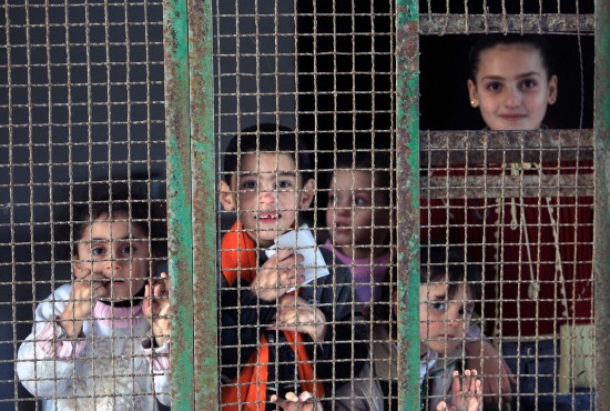 图文:几名巴勒斯坦孩子在铁栅栏内向外张望