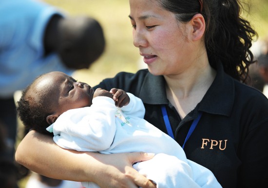 图文:中国警察防暴队员怀抱一名4个月大孤儿