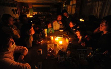 14日晚,日本宫城县山元町,地震灾民在停电的避难所内点燃蜡烛度过长夜
