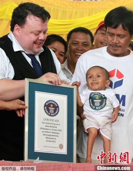 6月12日，菲律宾北三宝颜省，吉尼斯世界纪录总编Craig Glenday（左）向Junrey Balawing颁发“世界最矮人”证书。