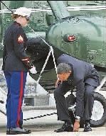 美国总统奥巴马当地时间3月30日在乘坐专机出行前为—名海军陆战队女中土弯腰捡起—枚硬币。