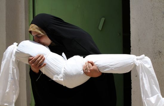 影像2010-伊拉克妇女亲吻被白布包裹起来侄女