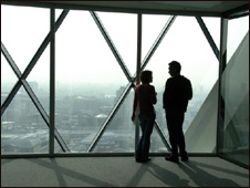 Two people chat by the window inside the Gherkin tower