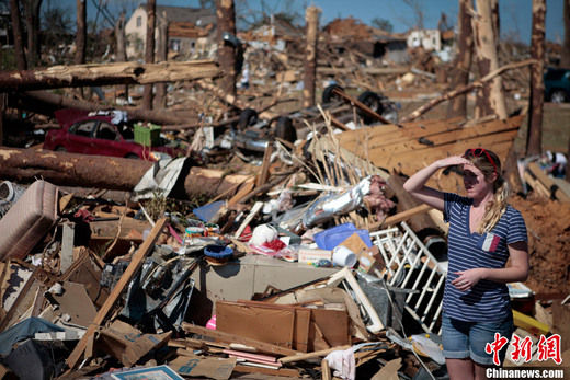 4��28�գ�������������������˹��¬����һ������Ů��վ�ڱ�������ݻٵķ��ݺͽ���������