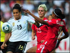 Germany's Celia Okoyino da Mbabi (in white) competes for the ball with Canada's Sophie Schmidt and Candace Chapman (far right) at the Women's World Cup