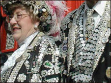 A Pearly King and Queen wearing clothes with pearl buttons sewn on