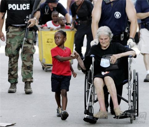 18. A 5-year-old kid and a 105-year-old victim of Hurricane Katrina evacuated from the convention center with hands holding in New Orleans. °¶쫷Уһ5С105Яִӻչɢ