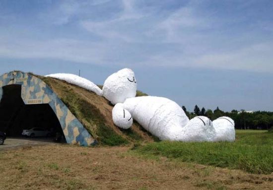 A 25.3-meter-long giant rabbit designed by Dutch artist Florentijn Hofman is displayed at an old aircraft hangar as part of the Taoyuan Land Art Festival in Taoyuan, northern Taiwan, Sept 3, 2014. [Photo/Agencies]