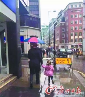 英国父亲牵着女儿只为自己打伞