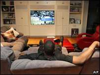 A man sitting on a sofa watching TV