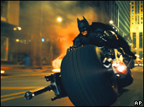 Batman drives his Batbike through Gotham City