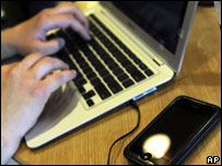 A man downloading music to his laptop and mp3 player