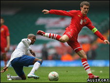 Aaron Ramsey of Wales (red shirt) competes against Ashley Young of England
