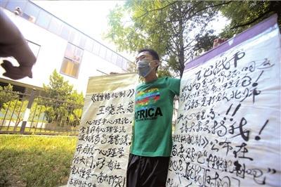 <b>男子在北师大手举“论战书”,希望有人来“应战”。本报实习记者曹宗文摄</b> <b>男子在北师大手举“论战书”,希望有人来“应战”。本报实习记者曹宗文摄</b>