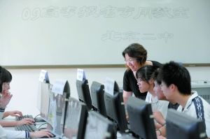 　昨日，北京二中，学生们在老师的辅导下进行高考网络报名。本报记者 薛珺 摄 
